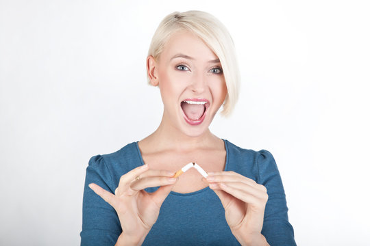 Happy blond lady holding a broken cigarette