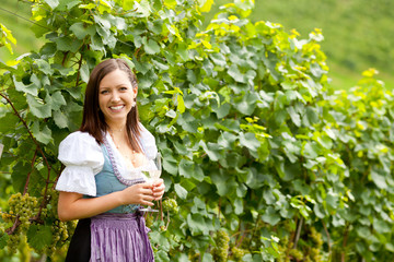 Frau mit Weinglas im Weingarten