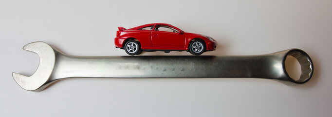 a small red car on a steel wrench