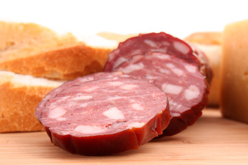 Sausage and bread on wooden surface