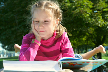 child girl reading at the park