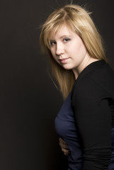 Fototapeta premium Portrait of a young blonde over black