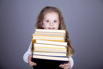 Little schoolgirl with books.