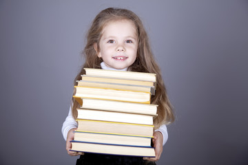 Little schoolgirl with books.