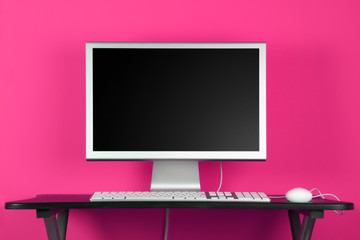 Desktop computer and pink wall - home office concept