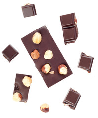Pieces of chocolate bar with nuts on white background