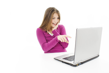 Surprised girl with laptop. Pointing at it.  Over white