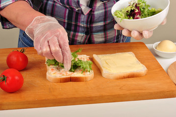 eine Scheibe Toastbrot wird mit Salat belegt