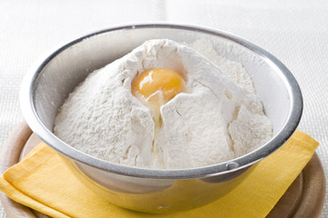 Fototapeta na wymiar White flour and egg in bowl