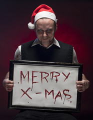 Horror Christmas Elf holding a sign written with blood.