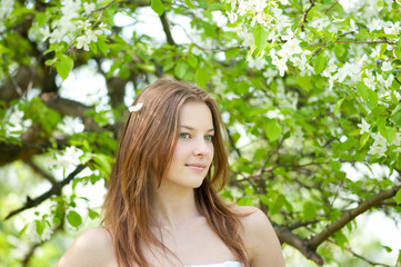 Beautiful young woman relaxing in apple tree garden