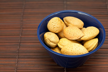 almonds in a bowl on a bamboo mat