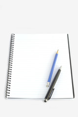Empty spiral notebook with pencil and pen