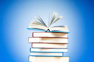 Stack of text books against gradient background