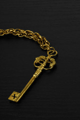 Fototapeta na wymiar Golden Antique Key on black wooden background