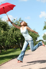 smiling girl jumping with red umbrella