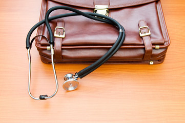 Doctor's case with stethoscope against wooden background