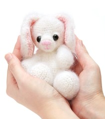 hands holdin a toy hare with caress
