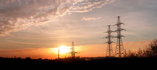 Electricity pylons and lines at dusk.