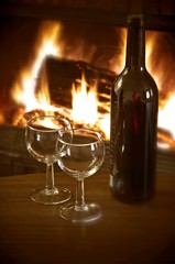 bottle of red wine in front of fireplace