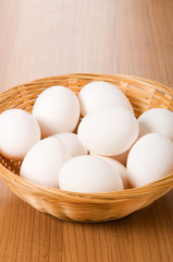 Many white eggs on the wooden table