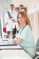 Portrait of beautiful nurse in front of medical people