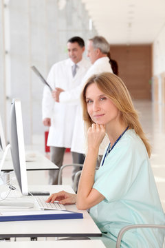Portrait of beautiful nurse in front of medical people