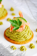 Avocado cream and prawns on crackers for Christmas