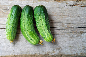 Three cucumbers on a wooden plate