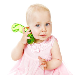 Baby girl with a green toy phone on white background