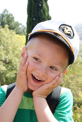 A little boy wearing a cap captain