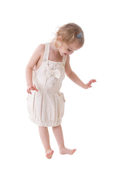 Happy little girl looking at her feet isolated on white