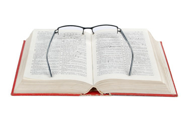 Obraz premium Eyeglasses and dictionary