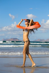 Naklejka premium young woman dancing with kerchief against the blue sky
