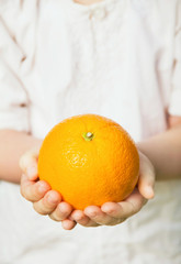 Child's Hands holding fresh ripe orange