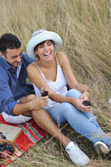 happy couple enjoying countryside picnic in long grass