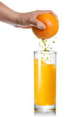 squeezing orange juice pouring into glass isolated on white