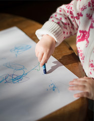 Fototapeta na wymiar Toddler young girl drawing with crayons