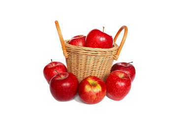 Red apples in a basket and near a basket isolated on a white bac
