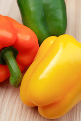 Fresh mixed pepper capsicums on chopping board