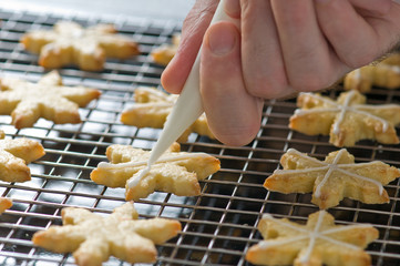 Backer decorates christmas cookies on the backing tray