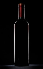 Red wine bottle silhouette over black background