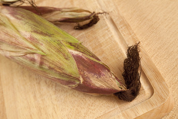 Maiskolben auf Holzbrett