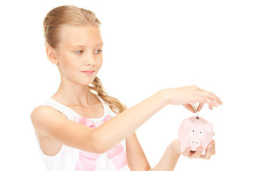 lovely teenage girl with piggy bank and money