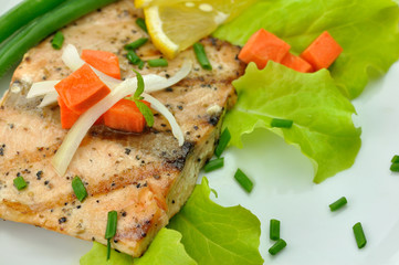 grilled salmon fillet with vegetables and lemon close up