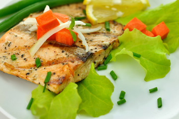 grilled salmon fillet with vegetables and lemon close up