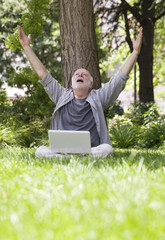 homme âgé connecté en wifi dans l'herbe
