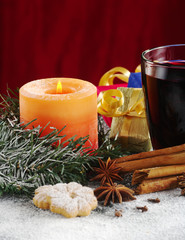 Candle and mulled wine with cookies, spices, gifts