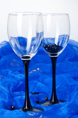 two glasses with beads on blue textile
