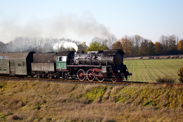 Fototapeta na wymiar Old retro steam train passing through polish countryside